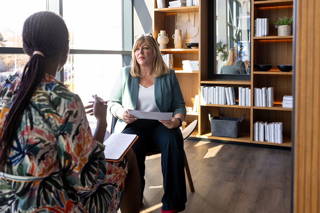 two professional women engaging in a business discussion in a stylish, modern office