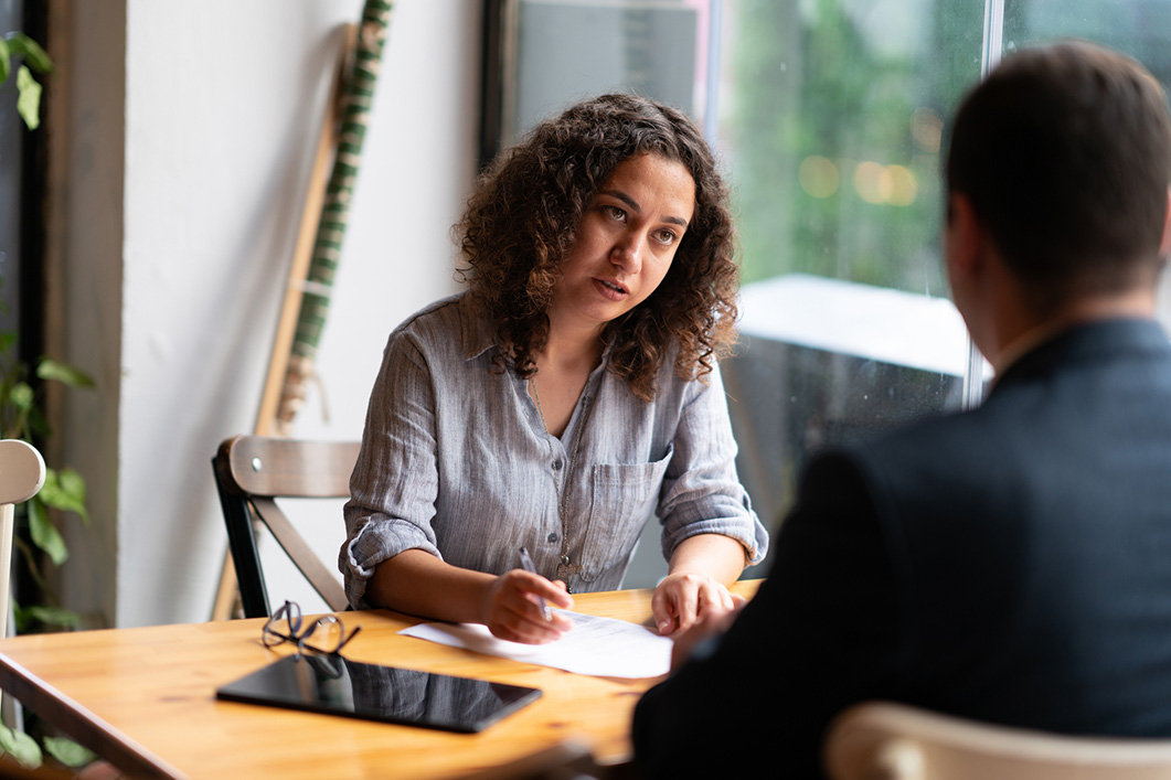 Two people sat having a conversation in a serious business meeting