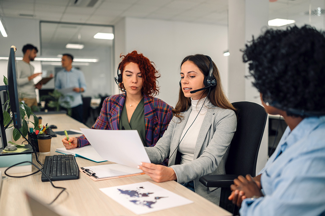 Call centre support agents discussing paperwork.