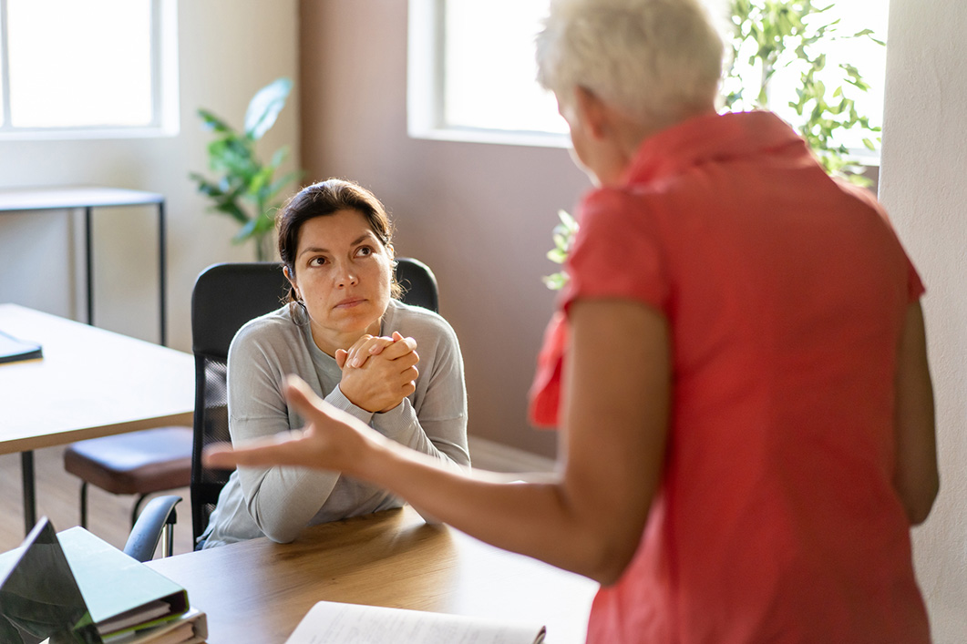A female manager is talking with her employee in her office stock photo