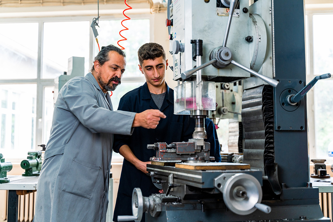 Teenage apprentice in technical vocational training with teacher