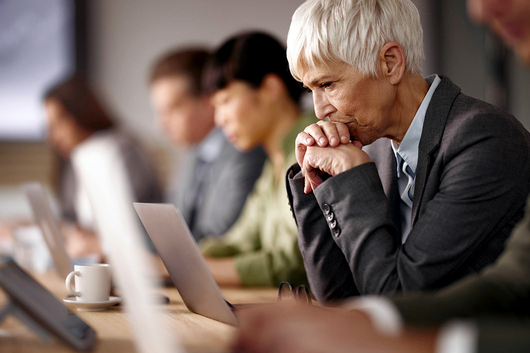 Worried senior businesswoman working on laptop in the office.