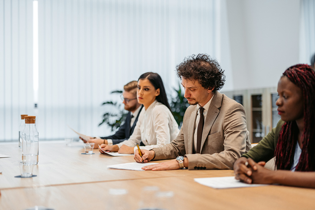 Group of people having a business meeting. They are signing a contract.