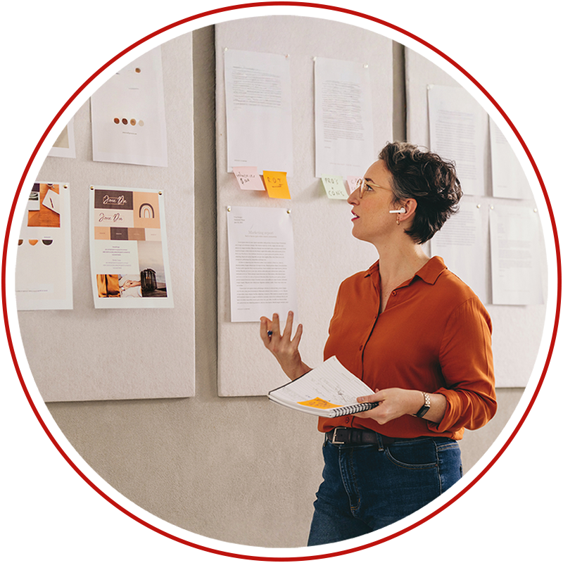 Business woman reviewing intellectual property assets pinned up on a wall