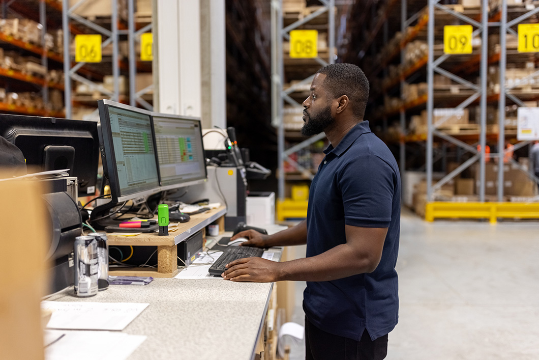 warehouse-worker-in-critical-supply-chain-uk-working-on-computer