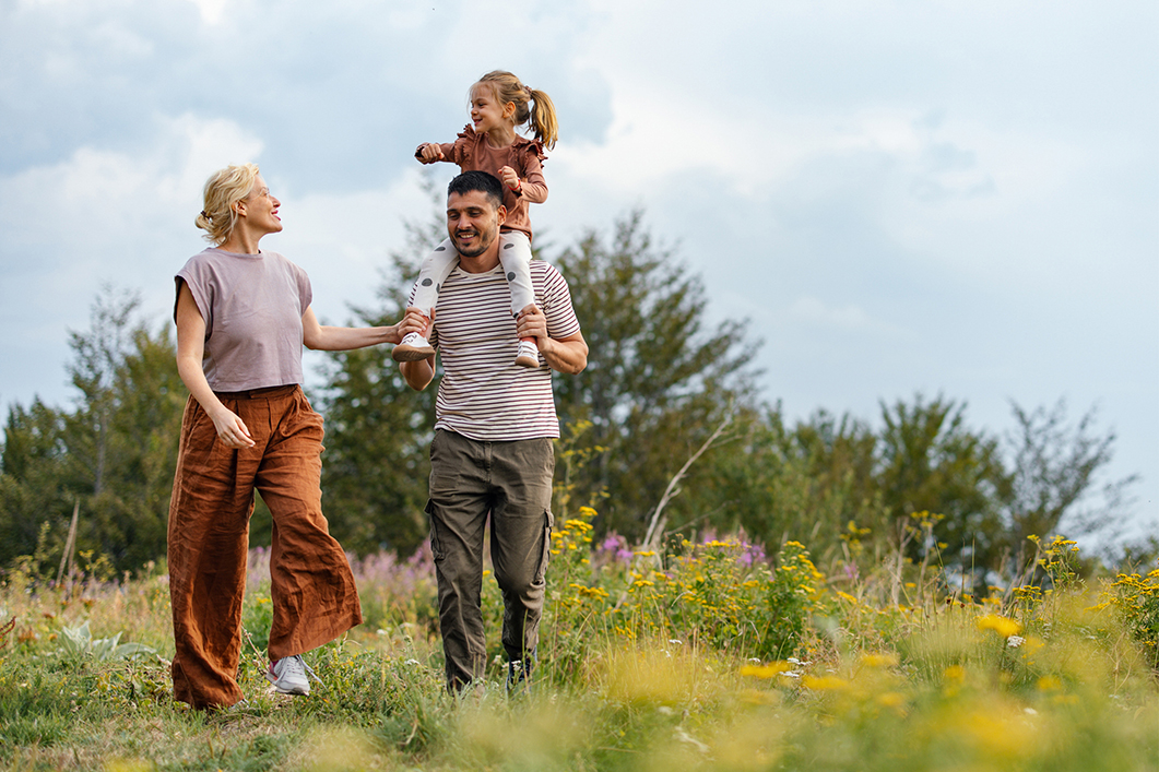 family_walking_through_countryside_field_during_summer