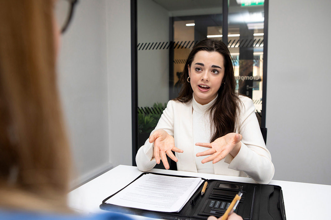 Young female candidate explaining during an interview in a modern office