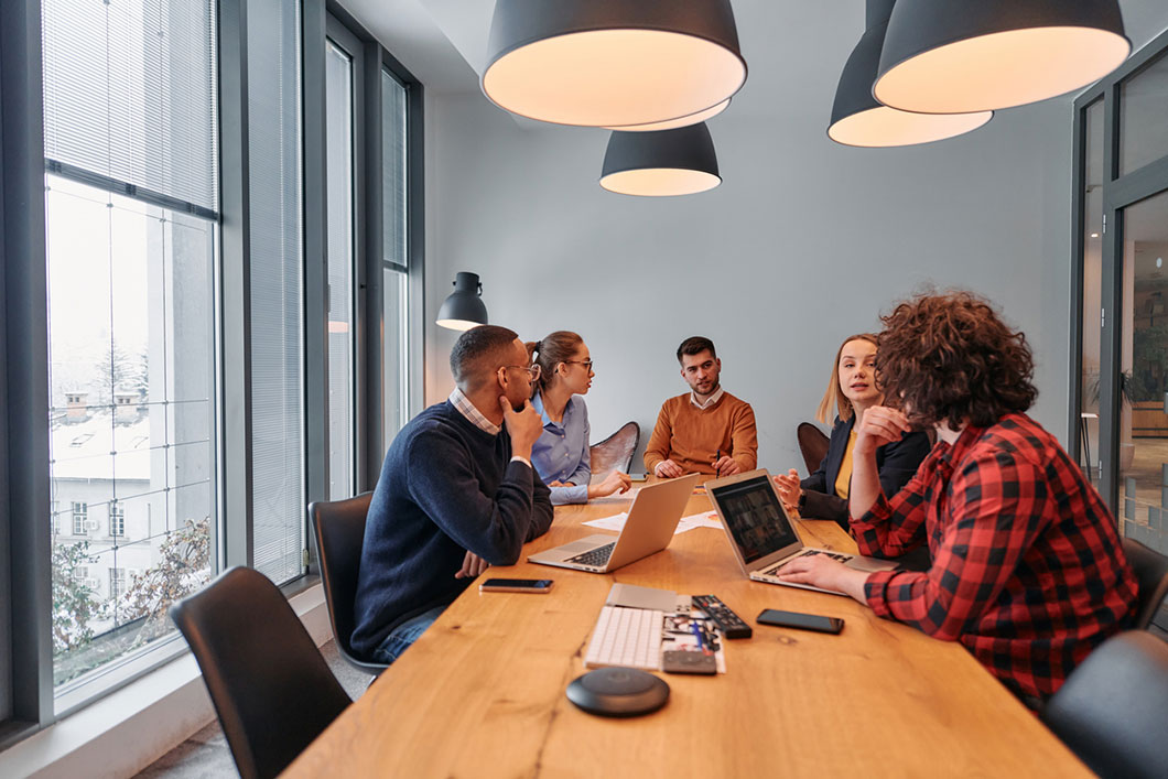 Colleagues sit around a board table.