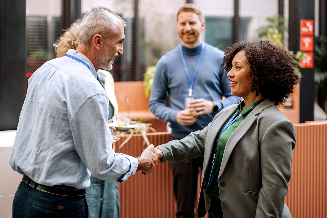 A group of business people with two shaking hands.