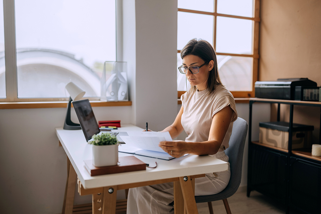 A woman sitting at her desk on a laptop in the office