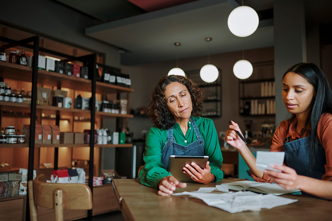 Two people at work look through paperwork
