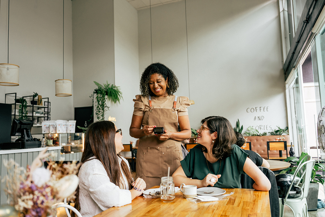 A waitress serves customers in a café.