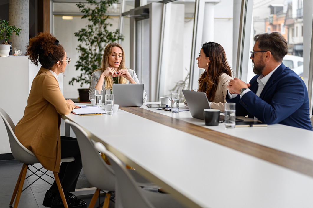 A group of colleagues sit in a meeting.