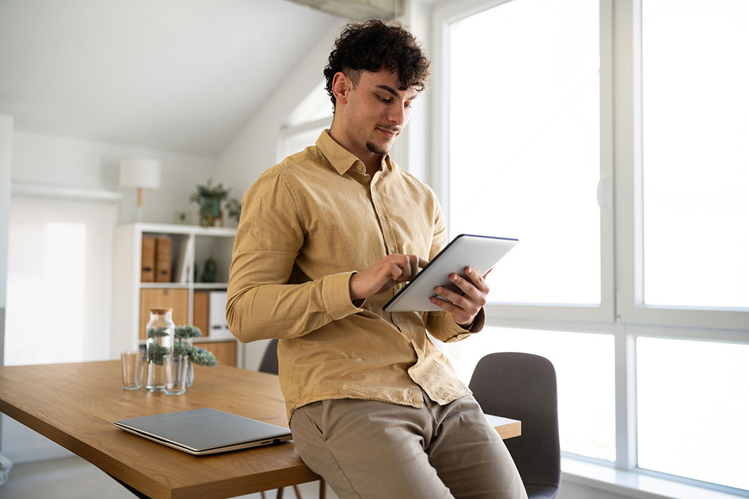 An office worker looks at a tablet.