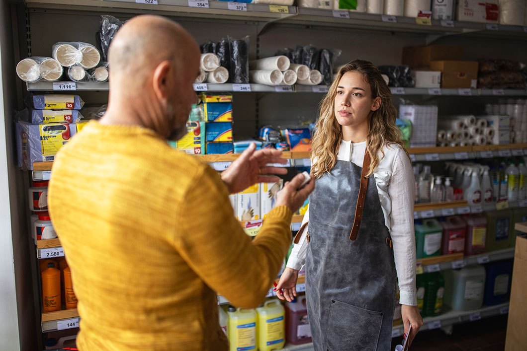 A shop worker talks to a customer