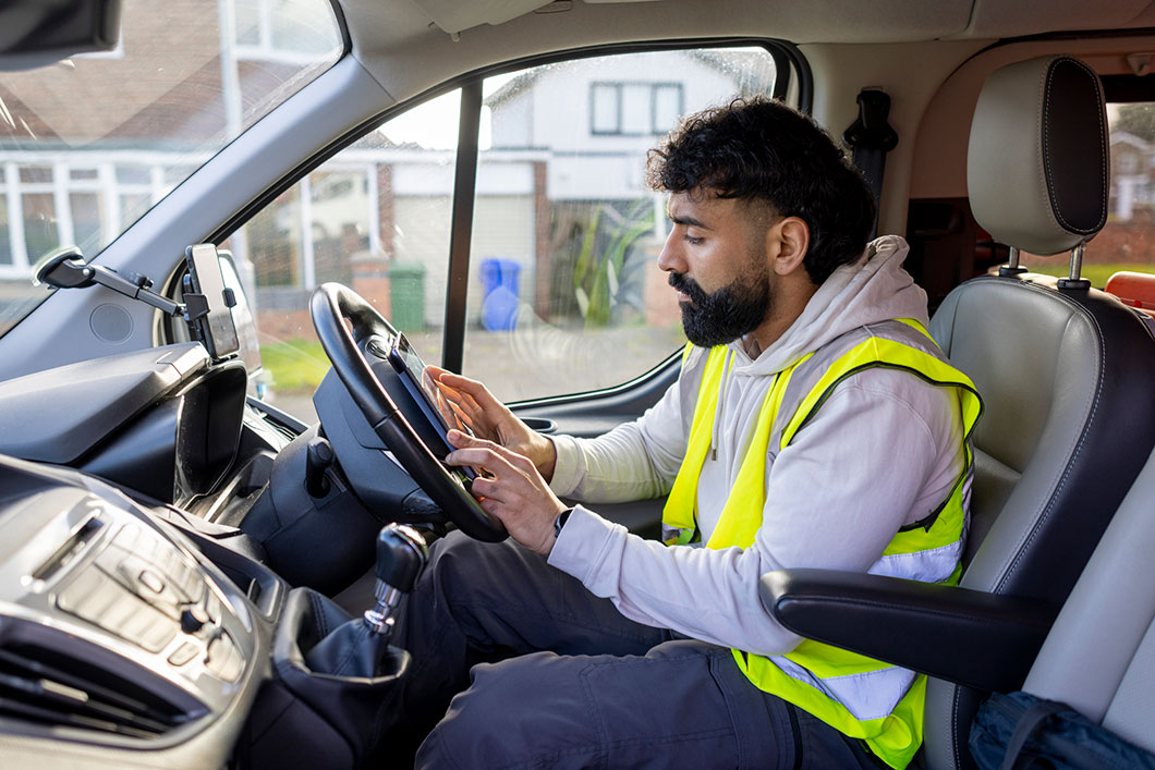 A driver in high vis sits in a van